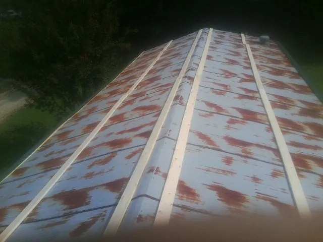Rusted metal roof panels with new wood purlins before replacement — Storm Damage Roof Repair in Central by Roofing Brothers
